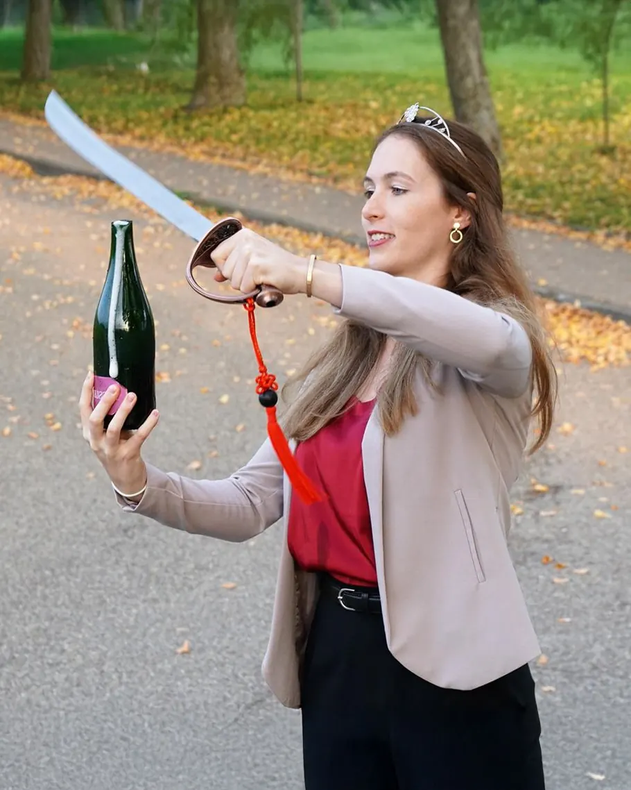 Weinprinzessin Henrike Heinicke beim sabrieren einer Flasche Sekt