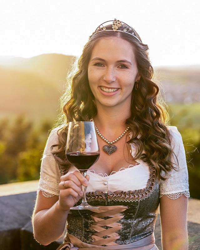 Henrike Maira Heinicke as wineprincess holding a glas of wine in a tradittional 'dirndl# dress